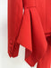 Red garment with a large bow detail on a white background