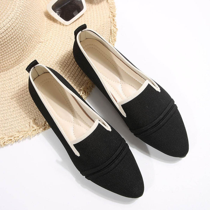 Black loafers with white soles on a light background