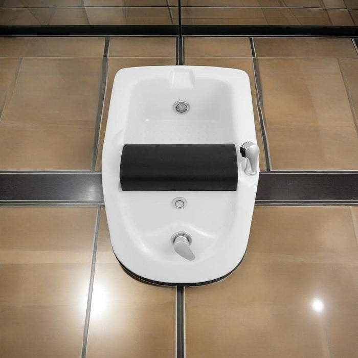 White bidet attached to a wall with black seat cover on a tiled bathroom floor.