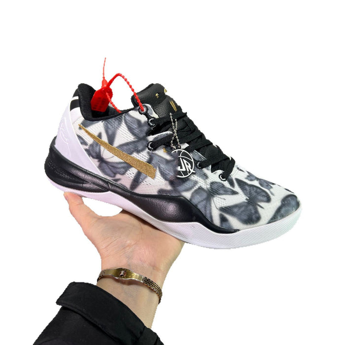 Basketball shoe with floral pattern held by a hand on a white background