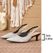 A pair of pointed-toe slingback pumps in a light metallic champagne-gray textured material with black heels and straps, displayed on a woven mat with a boho wall hanging in the background. A size marker indicating 5cm / 1.