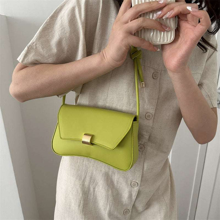 Person holding a lime green handbag with a neutral background