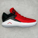 Red and black sneaker with white sole on a gray background