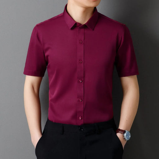 Person wearing a maroon short-sleeve shirt against a gray background