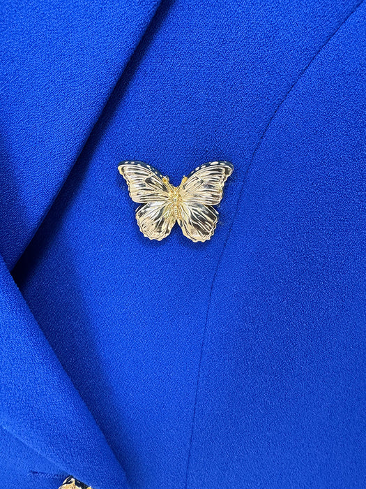 Gold butterfly pin on a blue fabric background