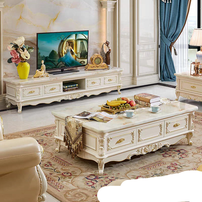 Living room with ornate white furniture, including a TV stand and coffee table, in a decorated room.