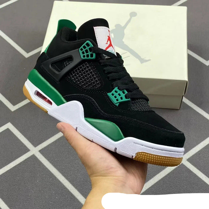 Black and green sneaker held in hand with Jordan box in the background