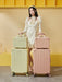 Woman holding two suitcases against a yellow background