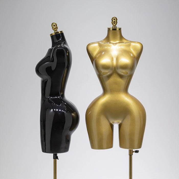 Black and gold female mannequins on a gray background