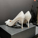 White lace high-heeled shoes with a bow on a dark surface, featuring the Chanel logo.